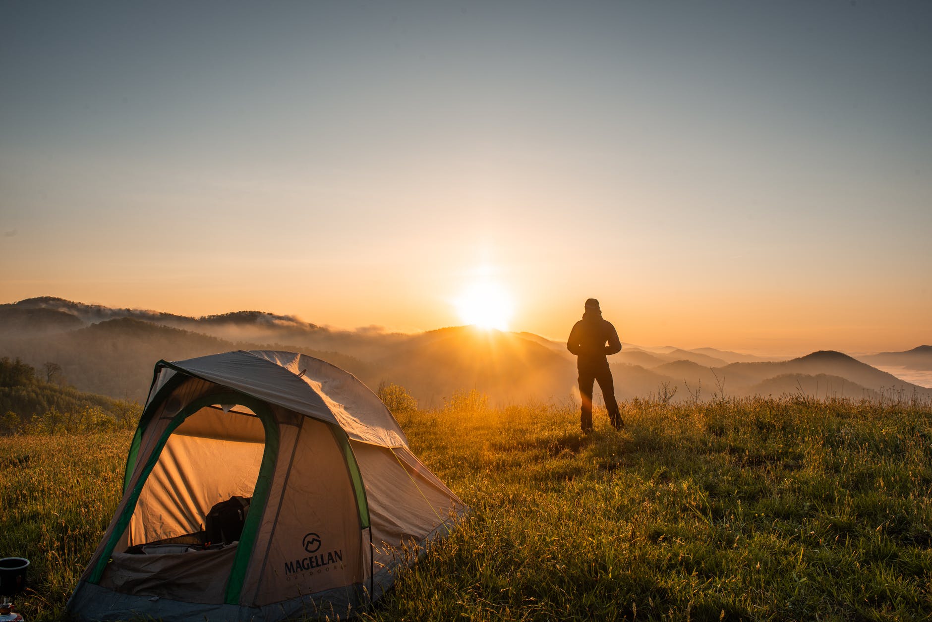 silhouette of person standing near camping tent