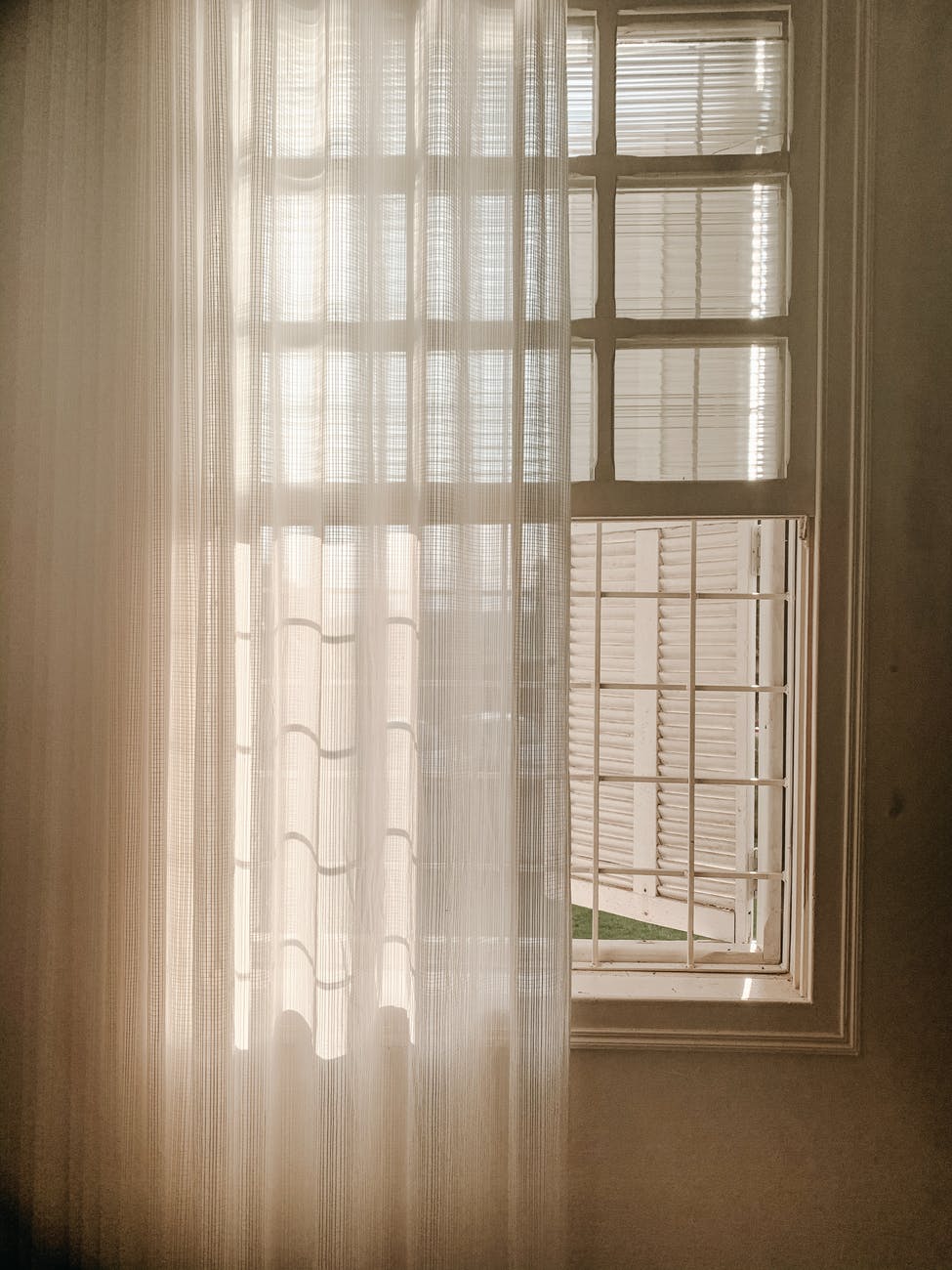 opened white window with sheer curtain