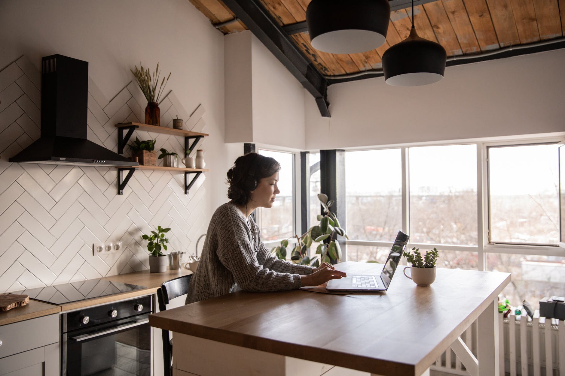 young woman surfing laptop in kitchen