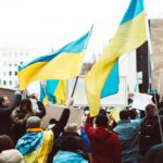 people gathering on street holding ukraine flags