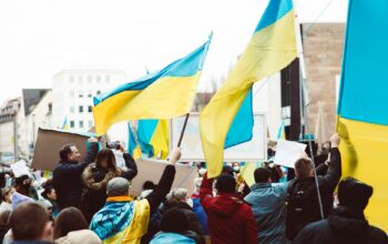 people gathering on street holding ukraine flags