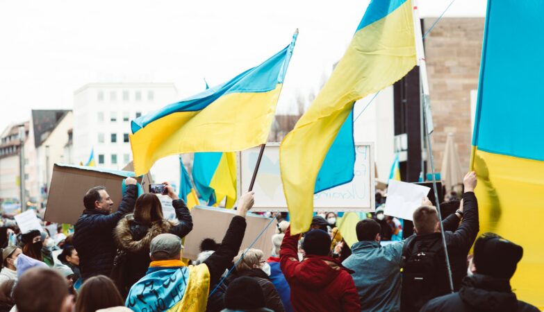 people gathering on street holding ukraine flags