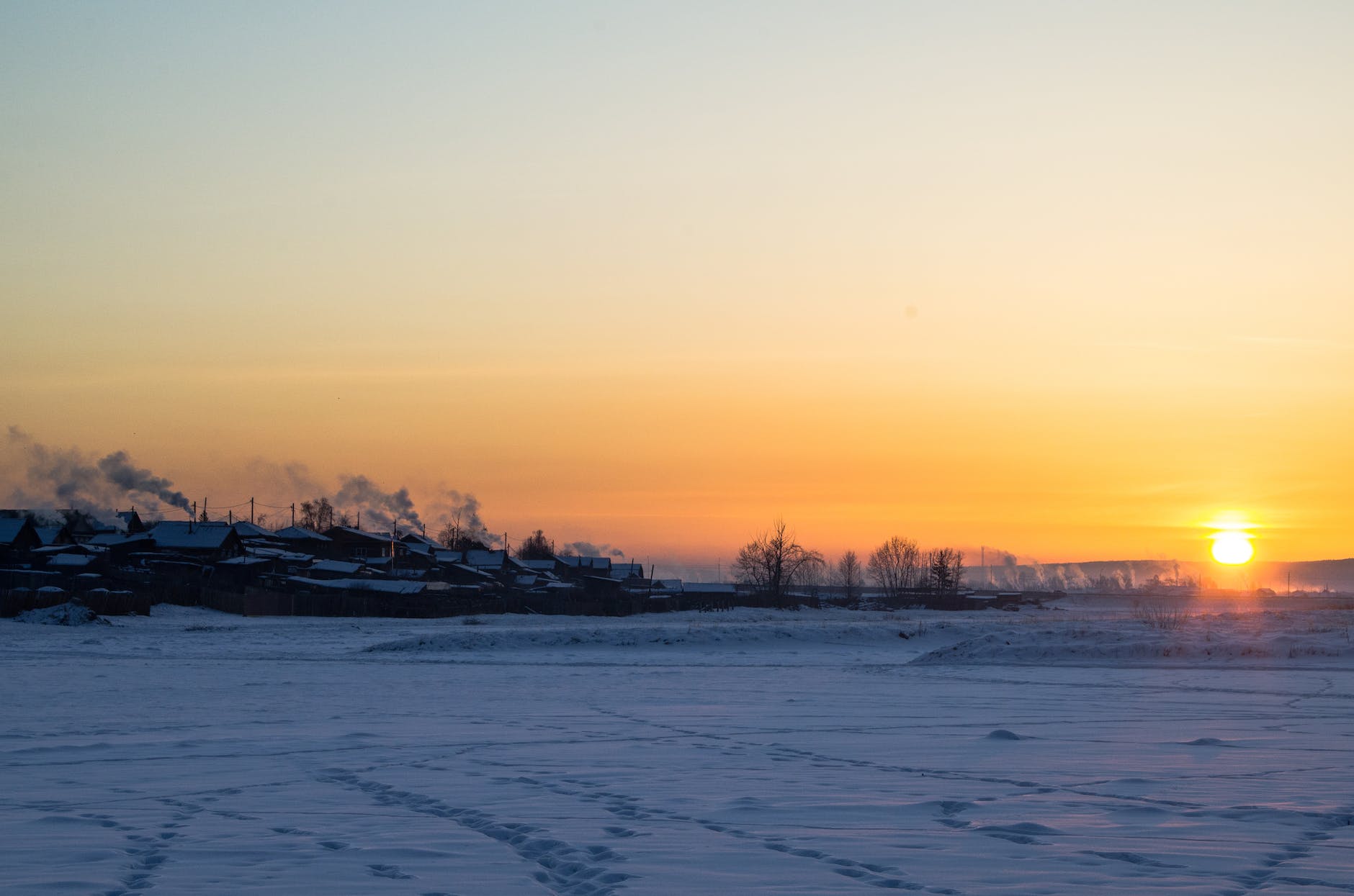 a snow covered field during sunset